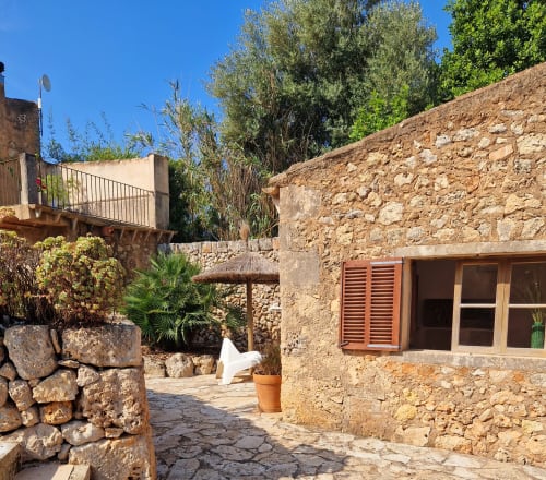 Cour rustique en pierre de la villa Las Fincas De Annie à Felanitx avec architecture traditionnelle et vue sur les montagnes