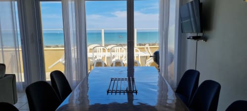 Dining table with sea view from cottage at Relais des Iles, Saint-Marcouf, overlooking beach and terrace