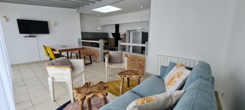 Séjour moderne au Relais des Îles avec canapé bleu, table à manger, cuisine et TV murale à Saint-Marcouf