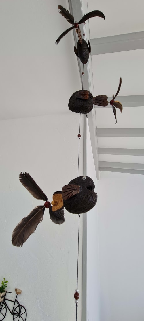 Mobile d'oiseau en bois artisanal suspendu au gîte Relais des îles, avec vue sur mer de Saint-Marcouf