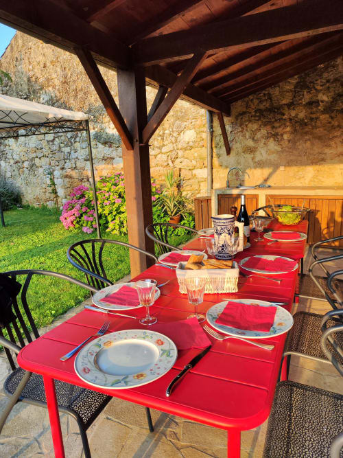 Table dressée dans la cuisine d’été du Rêve d’Alice, espace repas extérieur couvert en pierre