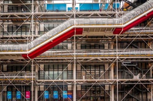 Façade d'hôtel moderne avec escaliers rouges, éléments vitrés et échafaudages métalliques à Paris, France