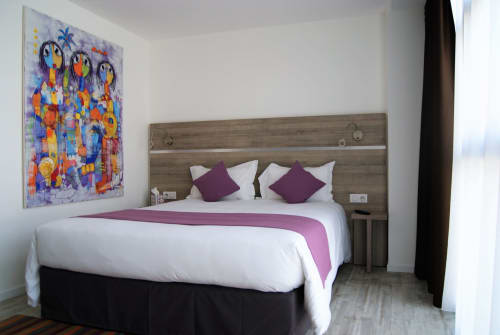 Chambre lumineuse et spacieuse, idéale pour un séjour confortable. Équipée d’un lit avec chemin de lit, bureau avec chaise ergonomique, télévision à écran plat, et table haute avec chaises près de la fenêtre. Profitez de la lumière naturelle abondante grâce aux grandes fenêtres, d’œuvres d'art vibrantes, et d’un miroir pleine longueur. Parfait pour un séjour agréable et productif dans notre appart'hôtel.