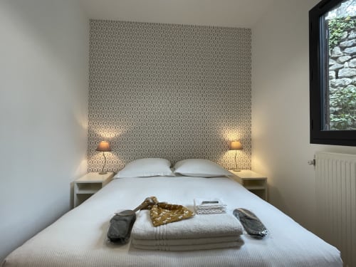 Chambre douillette du gîte Le Paradis de Lucile à La Roche Guyon avec tête de lit patterned et lampes de chevet