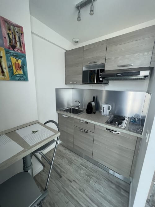 Chambre d’hôtel lumineuse avec un grand lit, une décoration moderne et un coin salon, idéale pour un séjour confortable à La Penne sur Huveaune.
