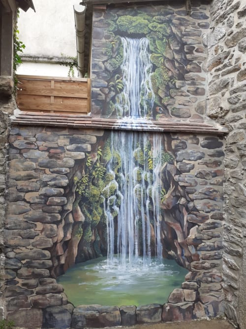 Fresque de cascade dans la cour en pierre du refuge des Alpes mancelles, Fresnay-sur-Sarthe