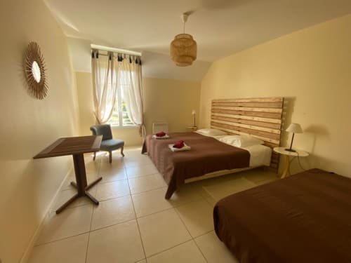 Geräumiges Duplexschlafzimmer in La Croix De La Jarrie mit Doppelbetten, Holzkopfteil und Gartenblick in Châtres, Frankreich.