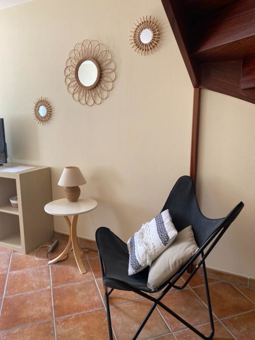 Moderner Wohnbereich in einer Duplex-Wohnung in La Croix De La Jarrie mit schwarzem Butterfly-Sessel, dekorativen Spiegeln und Beistelltisch