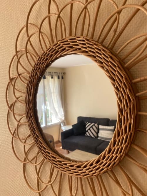 Geflochtener Rattan-Sunburst-Spiegel, der schwarzes Sofa in der Duplex-Wohnung La Croix De La Jarrie, Châtres, widerspiegelt