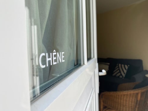 Fenster mit der Aufschrift 'À CHÈNE' im Bed & Breakfast La Croix De La Jarrie in Châtres, Frankreich, mit Blick auf den inneren Sitzbereich