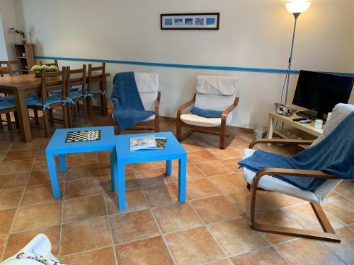 Gemütliches Wohnzimmer in La Croix De La Jarrie mit blauen Sesseln, Schachtisch und Fernseher in Châtres