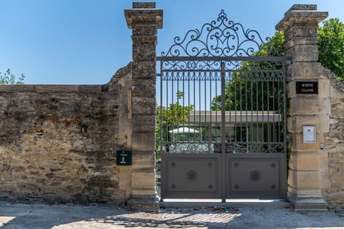 Ornate wrought iron gate entrance to Le Pavillon M boutique hotel and spa in Grignan, France