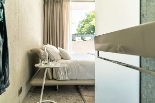 Modernes Schlafzimmer im Pavillon M mit weißem Bett, minimalistischem Nachttisch und Terrassenblick in Grignan