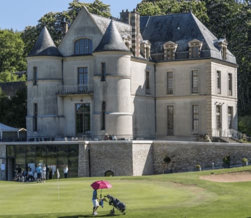 Le château Paradis de Lucile à La Roche-Guyon avec un golfeur sur la pelouse, tourelles et architecture historique