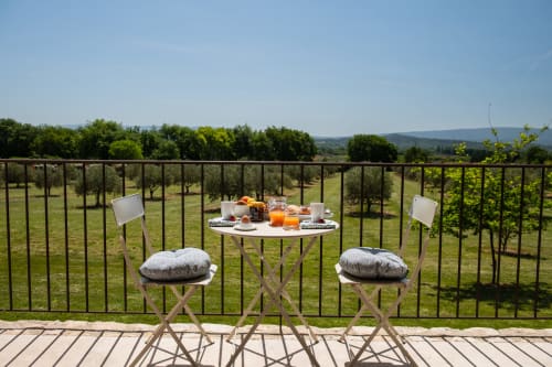 Breakfast on the terrace with a view of the olive trees and the Luberon at Bastide Toujours Dimanche, Gordes, Provence, France.