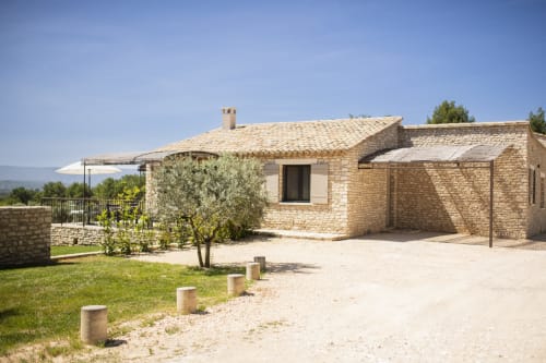 Dry stone house, shaded car parking, and peaceful atmosphere at Bastide Toujours Dimanche, Gordes, Luberon, France.