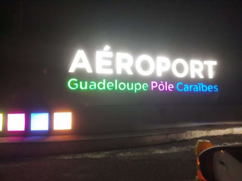 Guadeloupe Pôle Caraibes Airport illuminated neon sign at night near Saint-François
