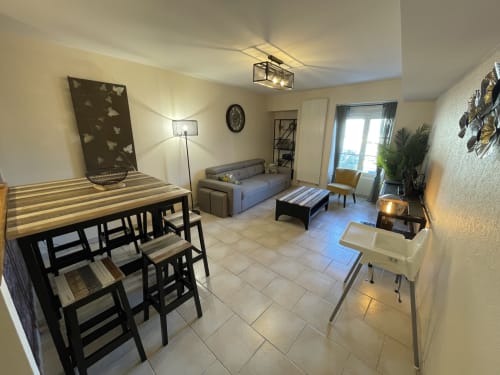 Gemütliches offenes Wohnzimmer mit Esstisch, blauem Sofa und Stadtblick im Ferienhaus Gites des Trois Provinces