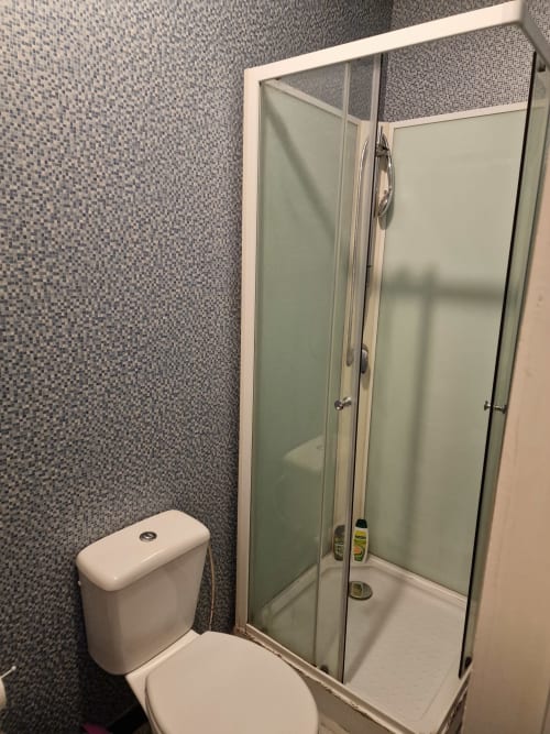 Salle de bain moderne à la Résidence Mantekila à Marcinelle avec douche vitrée et carrelage mosaïque