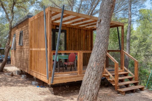 Cabine de glamping en bois moderne avec terrasse, vue sur jardin et grands arbres à Camping La Lézardière, La Valette du Var