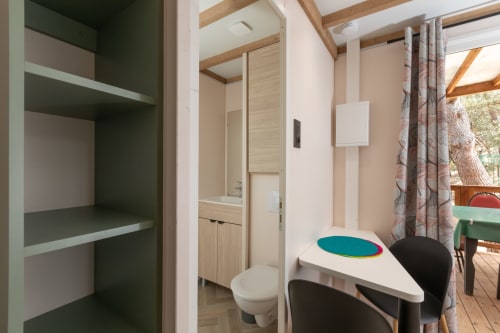 Chambre avec bureau, rangements et salle de bain attenante, vue sur le jardin à Camping La Lézardière