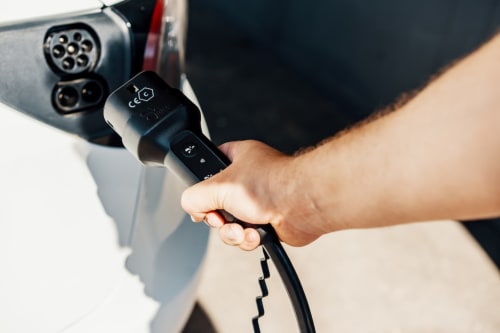 Mano che regge il cavo di ricarica EV presso Casa Mirko B&B, Arezzo - stazione di ricarica per veicoli elettrici