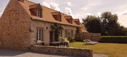 Charming stone cottage with terracotta roof, garden seating area, and landscaped grounds at Domaine De La Ronville in France