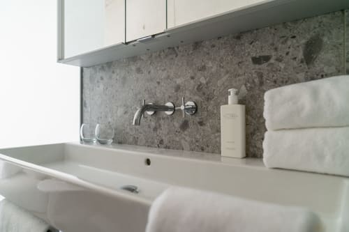 Modernes Badezimmer mit Wandwaschtisch, Marmorrückwand, weißen Handtüchern und Seifenspender im Le Pavillon M, Grignan