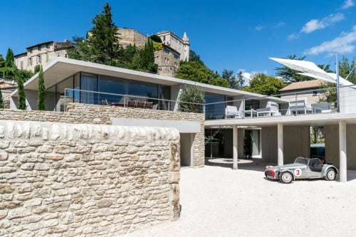 Modern white villa with stone facade at Le Pavillon M in Grignan, featuring terrace and vintage car