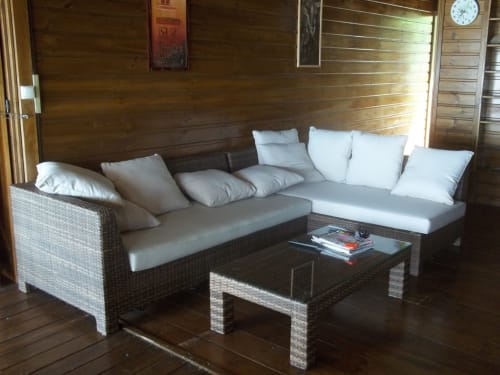 Salon moderne avec mobilier en rotin et coussins à la villa Les Hauts De Deshaies, Guadeloupe