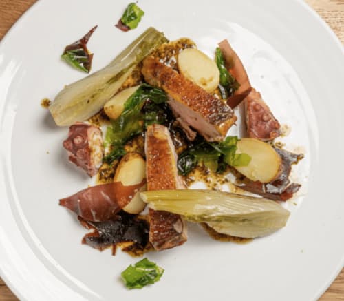 Kunstvoll angerichtetes Meeresfrüchte-Gericht mit Oktopus, Kartoffeln und Gemüse im Loup Castel Boutique Hotel in Le Bar-sur-Loup