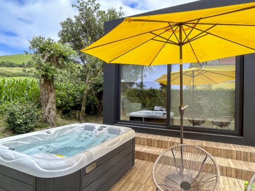 Villa Várzea hot tub with yellow umbrellas on wooden deck overlooking countryside