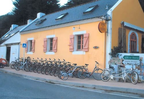 Yellow building with bikes parked outside at Locations Loc'Maria, Belle île en Mer