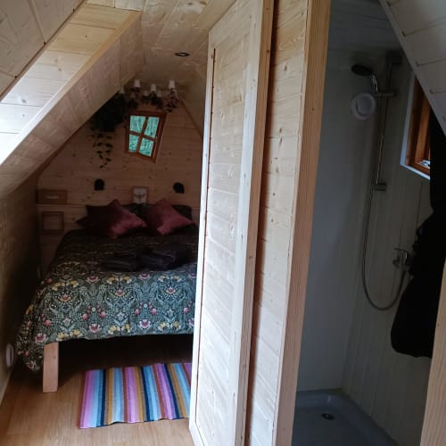 Chambre loft chaleureuse aux Refuges Du Chalet à Jalhay avec poutres apparentes, literie colorée et salle de douche privée