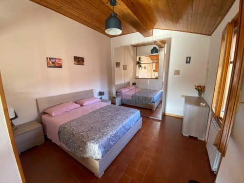 Spaciosa camera da letto in L'Appartamento Giusto Bologna con letto matrimoniale, armadio specchiato e soffitto in legno