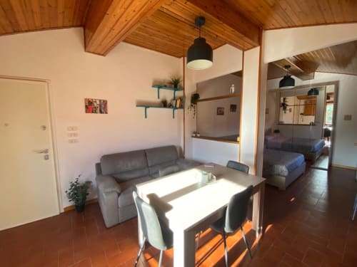 Appartamento Social Costa a L'Appartamento Giusto a Bologna: open-plan con tavolo da pranzo, divano grigio, arredi in legno