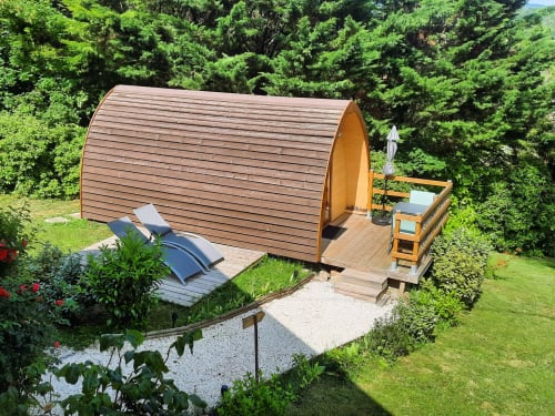 Wooden barrel glamping pod with deck and loungers at Belloréade in Belloc, surrounded by lush garden