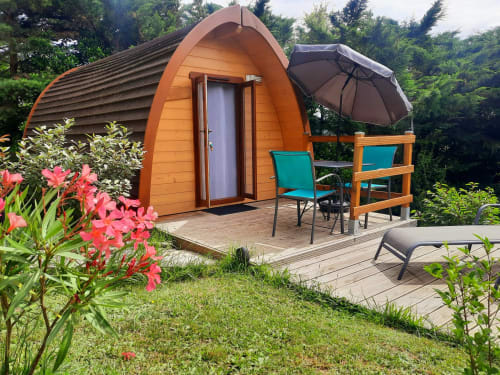Orange glamping pod at Belloréade with terrace, garden flowers, umbrella, and loungers in Belloc