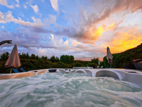 Hot tub at sunset overlooking gardens at Belloréade B&B in Belloc, France