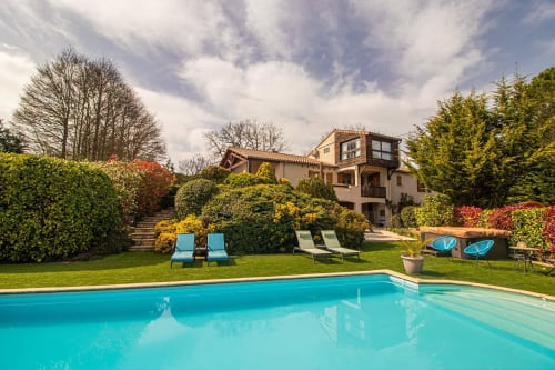 Belloréade luxury villa in Belloc with turquoise swimming pool, loungers, and lush gardens overlooking mountains