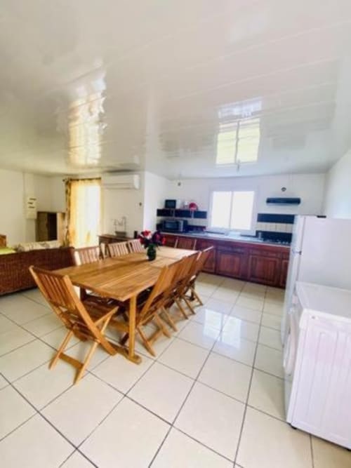 Cuisine spacieuse et salle à manger à la guest house Case Vi D'O à La Plaine des Cafres avec table en bois et équipements modernes