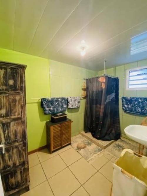 Salle de bain vert citron lumineux avec rideau de douche noir à la villa Case Vi D'O à La Plaine des Cafres