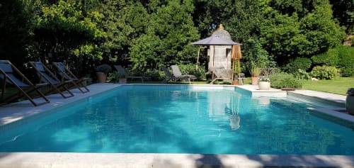 Piscine du Logis des Tourelles à Cognac, entourée d'arbres et de chaises longues