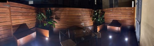 Outdoor patio at Maison Vaticana Guest House Rome with wooden walls, potted plants, and ambient lighting