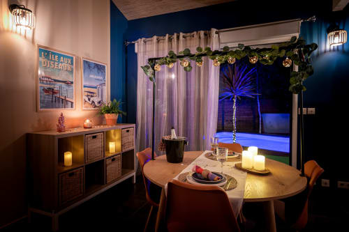 Élégante salle à manger de la Villa Eden Bleu avec vue sur la piscine, table décorée et ambiance lumineuse bleue à Biscarrosse