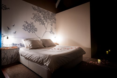 Modern bedroom at Villa Eden Bleu with tree mural, romantic lighting, and striped bedding in Biscarrosse