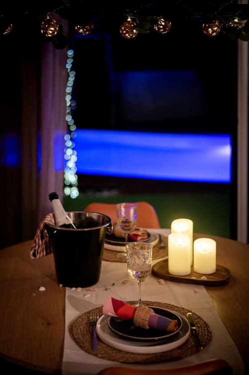 Élégante table à la Villa Eden Bleu avec dîner aux chandelles, seau à champagne et éclairage néon bleu
