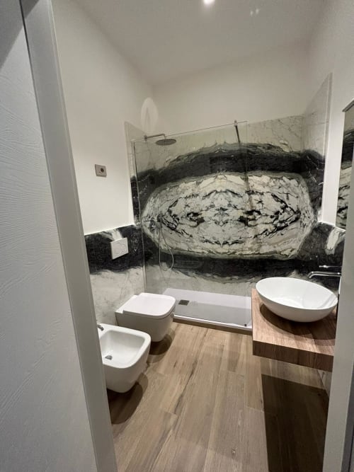 Bagno moderno con accenti in marmo, sanitari bianchi e doccia a pioggia presso il B&B Breccia nel Mare a Marina di Carrara