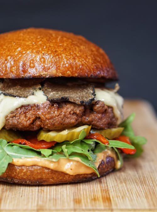 Gourmet burger with beef patty, melted cheese, caramelized onions, and fresh greens on toasted bun at Seabrook Lodge, Clifden