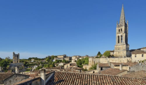 Château Haut Clarise, gîte de charme à Belvès-de-Castillon, avec le clocher de pierre dominant les toits médiévaux et la campagne
